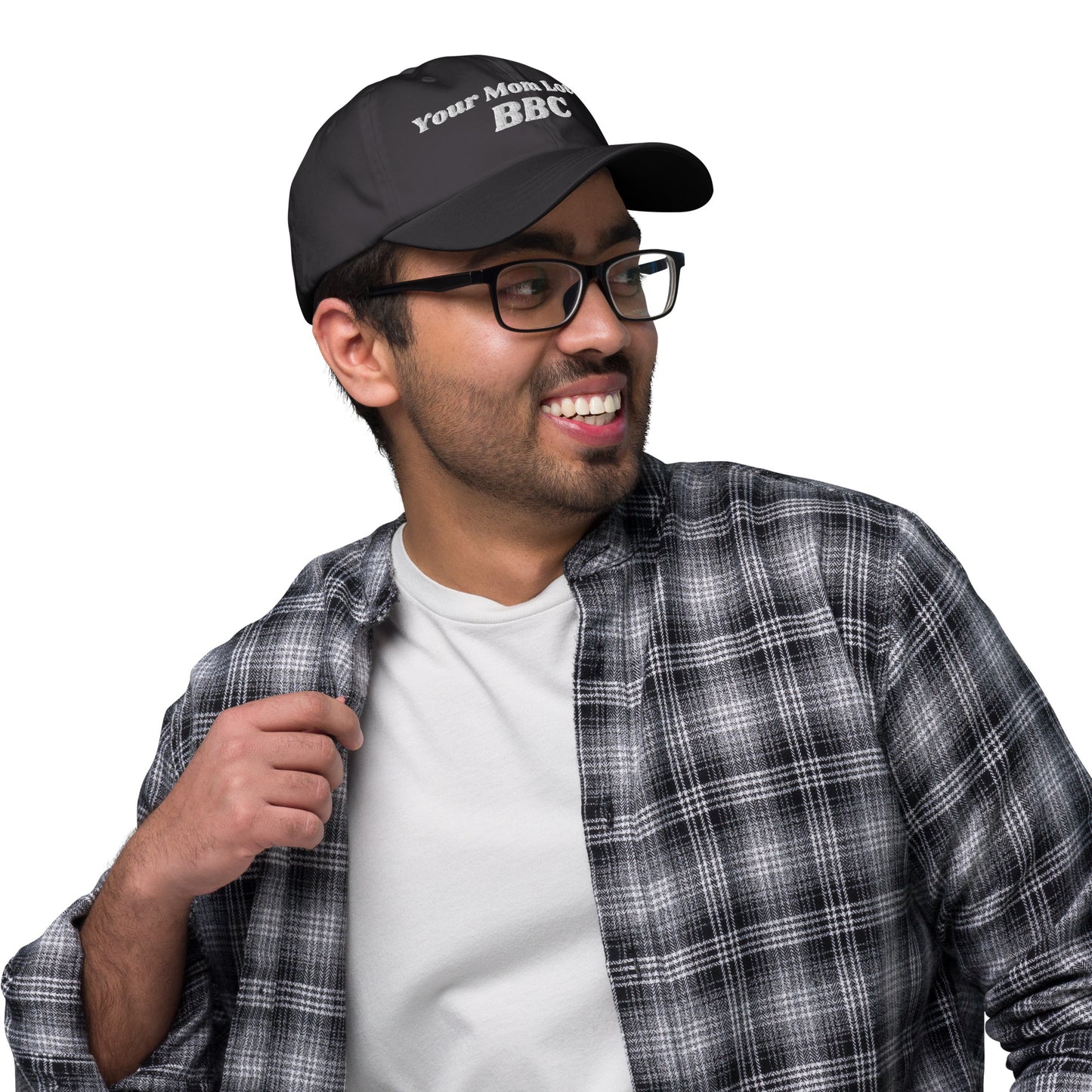 A person wearing a Bougie Boiz Clubs Your Mom Loves BBC embroidered hat, hands resting on the cap. Dressed in a black and white plaid shirt, they are viewed from behind against a simple background.