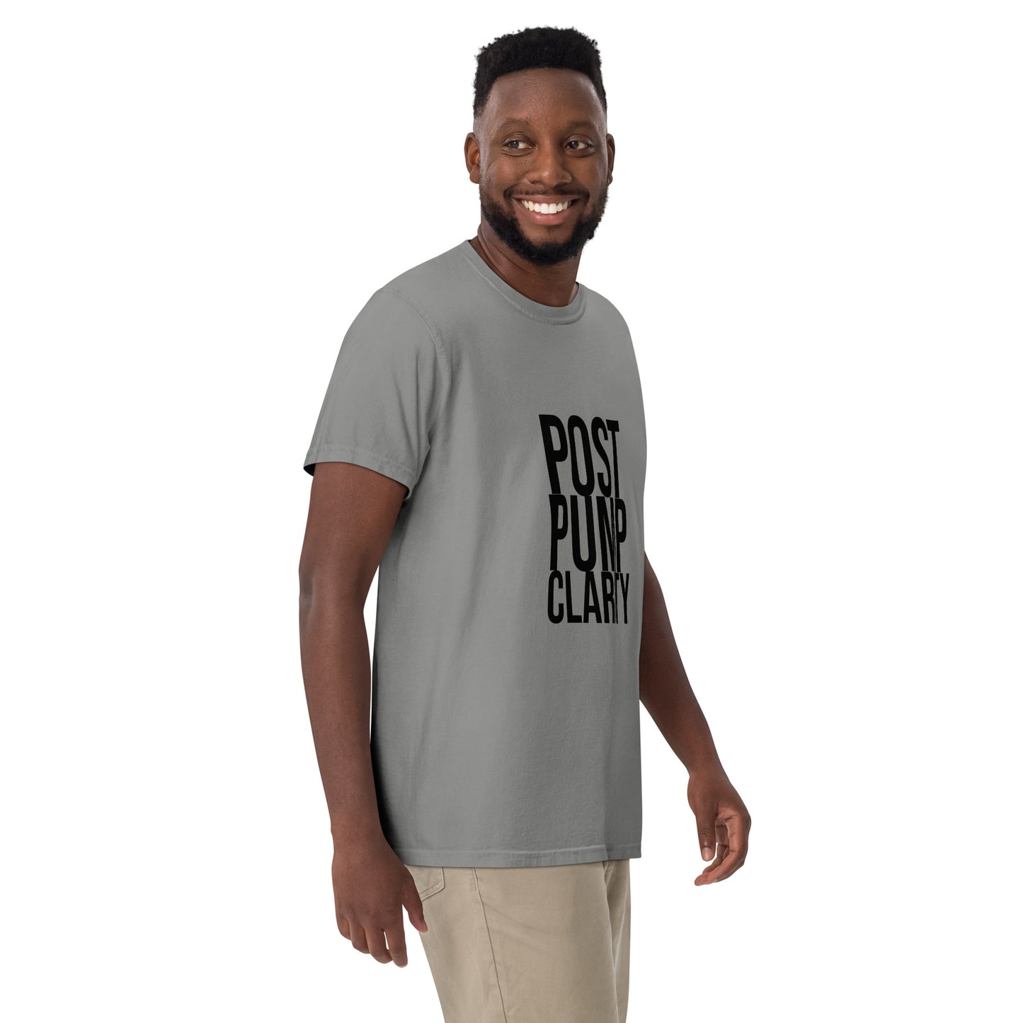 A person in a Bougie Boiz Clubs green Post Pump Clarity unisex T-shirt stands against a white background, smiling with one arm slightly bent.