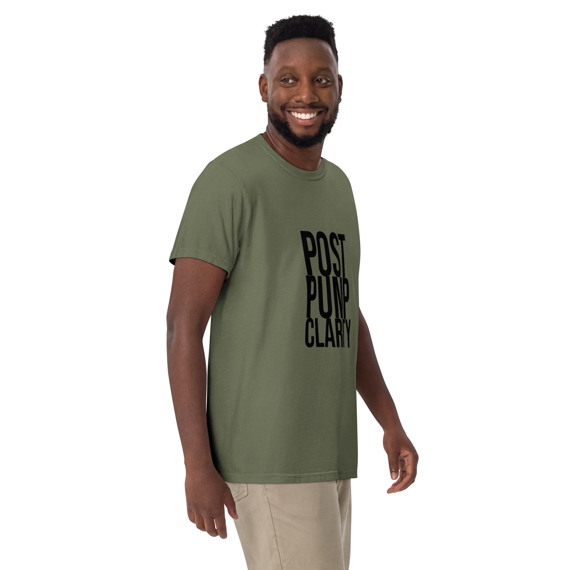 A person in a Bougie Boiz Clubs green Post Pump Clarity unisex T-shirt stands against a white background, smiling with one arm slightly bent.