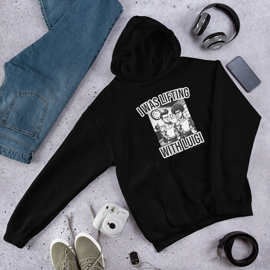 A Bougie Boiz Club Lifting With Luigi unisex hoodie in black, showcasing a cartoon image and catchy phrase, is displayed on gray. Nearby items like jeans, headphones, a camera, shoes, and a smartphone create gym-ready vibes for stylish lifters.